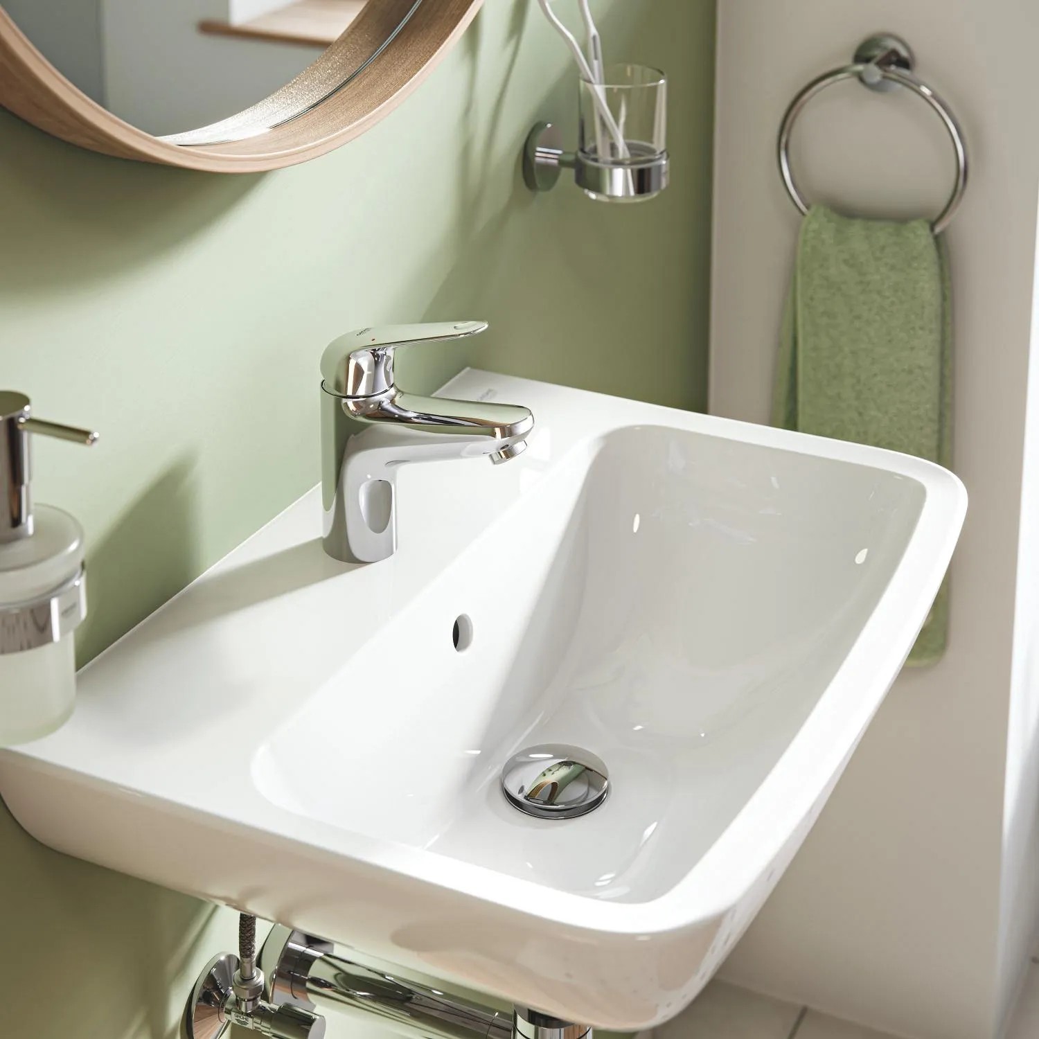 Umývadlová batéria Grohe Swift S-Size na bielom umývadle. Jednopáková batéria s chrómovým povrchom. Umývadlová batéria Grohe Swift S-Size na bielom umývadle. Jednopáková batéria s chrómovým povrchom.