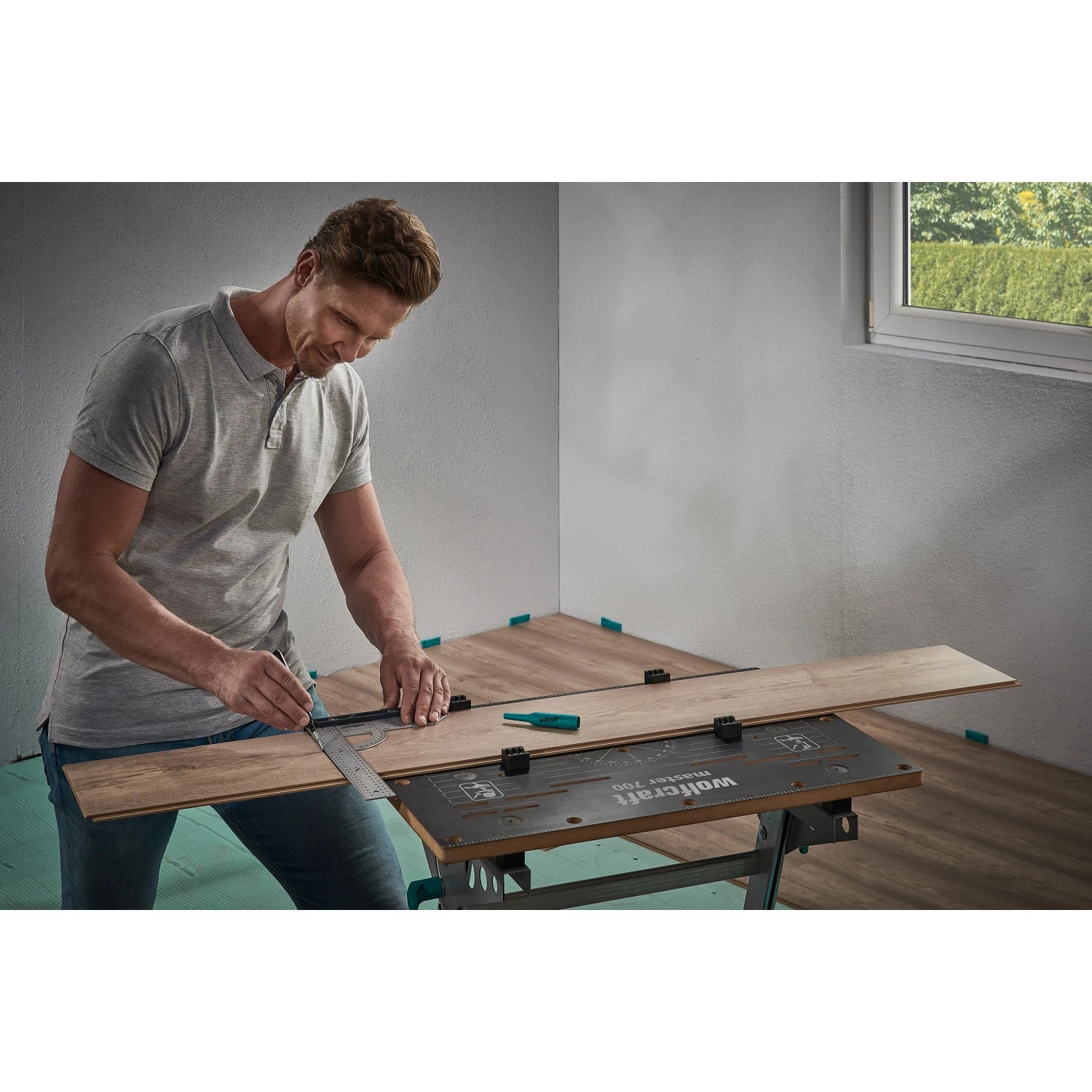 Muž používa sadu wolfcraft na montáž laminátových/dizajnových podláh na označenie kusu laminátu. Muž používa sadu wolfcraft na montáž laminátových/dizajnových podláh na označenie kusu laminátu.
