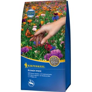 Kiepenkerl Kvetinová lúka 1kg: Balenie s kvitnúcou lúkou a motýľom na ruke.