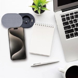 Stolová zásuvka s USB portami vedľa mobilného telefónu, poznámkového bloku a notebooku.