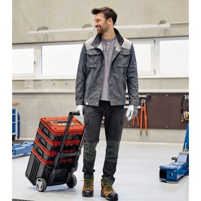 Muž ťahá kufor na náradie Einhell E-Case L s kolieskami. Mobilný transport náradia.