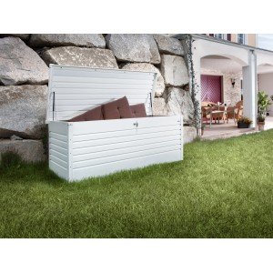 Otvorený, biely Biohort FreizeitBox Gr. 200 v záhrade, plný vankúšov.