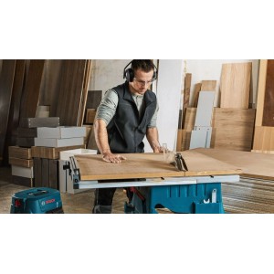 Stolová píla Bosch Professional GTS 254 v prevádzke s predĺžením stola a adaptérom na odsávanie.
