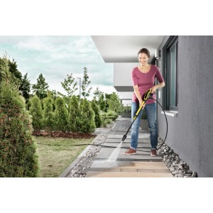 Žena čistí terasu pomocou Kärcher Universal Cleaner RM 555 a tlakového čističa.