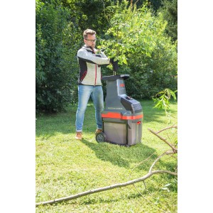 Al-Ko Valcový drvič Easy Crush LH 2810 v prevádzke: Muž vkladá konáre do záhradného drviča.