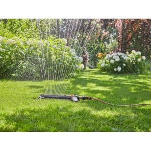 Zavlažovač Gardena AquaZoom L zavlažuje trávnik v záhrade.