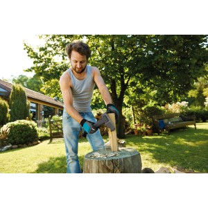 Muž štiepa drevo sekerou Gardena Universal Axe 1000 A (dĺžka 45 cm) na kláte v záhrade.