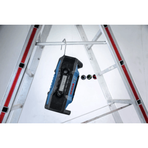 Akumulátorové rádio Bosch Professional GPB 18V-3SC visí na rebríku. Modré stavebné rádio s hákom pre flexibilné použitie.
