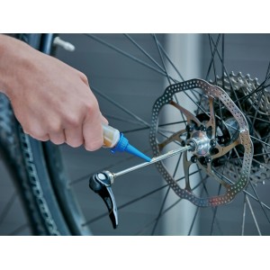 Aplikácia viacúčelového maziva na brzdový systém bicykla. Mazivo pre bicykle.
