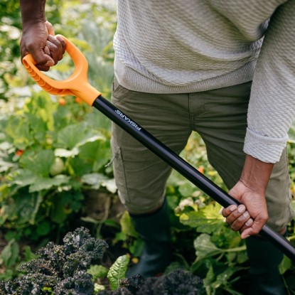 Osoba používa rýľovacie vidly Fiskars Solid v záhrade na obrábanie pôdy.