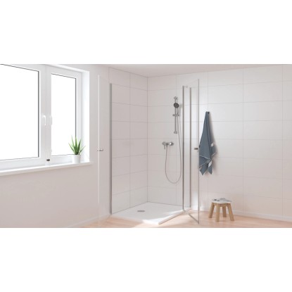 Sprchová batéria Grohe QuickFix Start v sprche s bielymi obkladmi a uterákom.