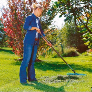 Žena hrabe trávnik hrabľami Gardena combisystem 60 cm v záhrade.