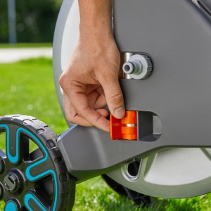 Detail: Ruka ovláda oranžový mechanizmus na súprave vozíka na hadicu Gardena Aqua Roll M.