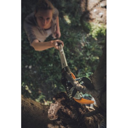 Žena strihá konár pomocou bypass nožníc Fiskars PowerGearX UPX82. Záhradné nožnice s dlhou rukoväťou.