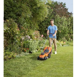 Akumulátorová kosačka Black+Decker BCMW3318L2 pri práci na trávniku.