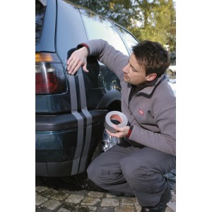 Muž aplikuje striebornú univerzálnu pásku Tesa Extra Power na auto. Všestranná páska.