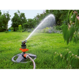 Turbínový zavlažovač Gardena Comfort so saňami v prevádzke, zavlažuje trávnik.