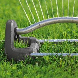 Zavlažovač trávnika Gardena Aqua S 220: Obdĺžnikový zavlažovač v prevádzke na trávniku, zavlažuje jemnými prúdmi vody.