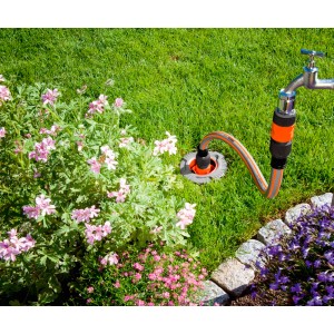 Pripojovacia súprava Gardena Profi-System pripojená k vodovodnému kohútiku v záhrade.