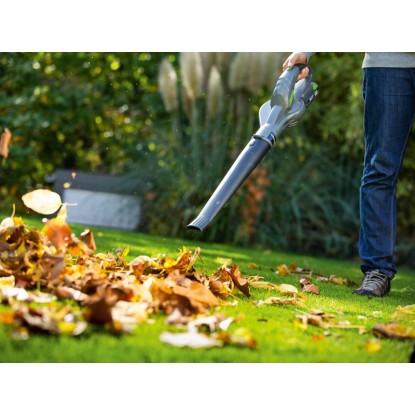 Akumulátorový fúkač lístia LUX-TOOLS pri odstraňovaní lístia v záhrade.