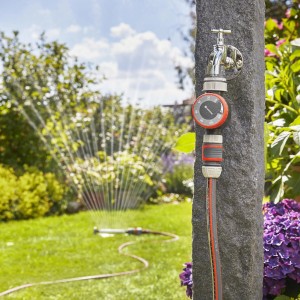 Zavlažovacie hodiny Gardena na kohútiku so záhradným postrekovačom.