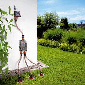 Automatický rozdeľovač vody Gardena so 6 výstupmi a zavlažovací počítač na bielej stene.