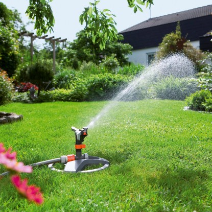 Zavlažovač trávnika Gardena Premium so saňami zavlažuje trávnik v záhrade.
