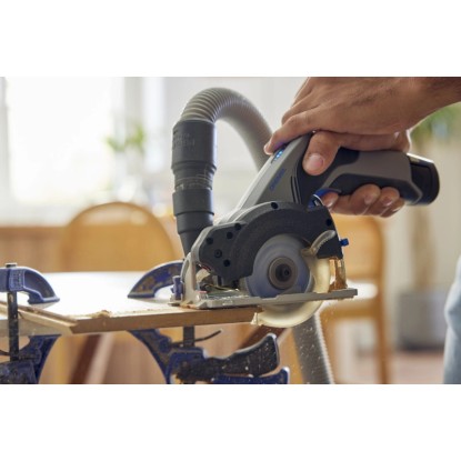 Dremel okružná píla CS12V-S1C v prevádzke s odsávaním prachu a obrobkom.