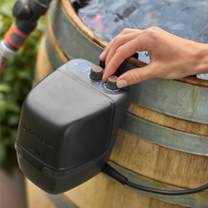 Akumulátorové čerpadlo do dažďového suda Gardena 2400 ComfortAutomatic Set na sude s rukou na ovládaní.