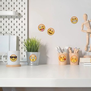 Rôzne samolepky na stenu s emotikonmi na bielom stole s dekoráciou.