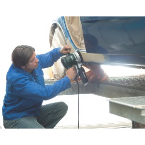 Muž brúsi auto excentrickou brúskou Metabo SXE 450 TurboTec. Brúska v prevádzke.