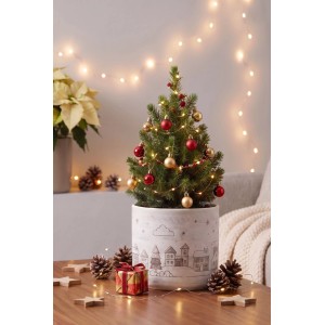 Okrúhly biely keramický kvetináč Cozy Homes s motívom zimnej dediny, ozdobený malým vianočným stromčekom.