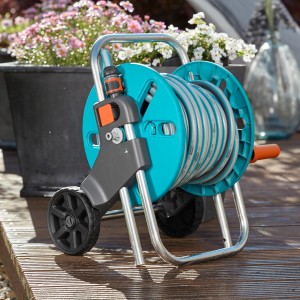 Sada vozíka na hadicu Gardena CleverRoll S s 20 m hadicou a príslušenstvom na drevenej terase.