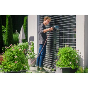Muž čistí žalúzie kefou na žalúzie Gardena Cleansystem s prípojkou vody.