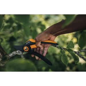 Nožnice Fiskars Bypass Plus P521 pri strihaní konára.