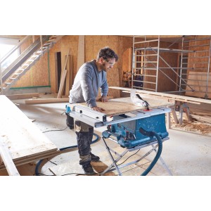 Stolová píla Bosch Professional GTS 635-216 v prevádzke s obsluhou a obrobkom.