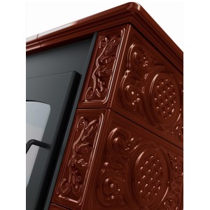 Detail hnedých krbových kachlí s kvetinovými ozdobami.