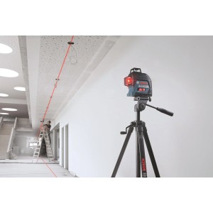 Čiarový laser Bosch Professional GLL 3-80 so statívom a červenou laserovou líniou v prevádzke.