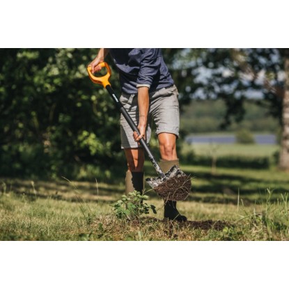 Osoba kope zeminu rýľom Fiskars Solid Pointed Garden Spade. Rýľ s rukoväťou D a špicatou čepeľou.