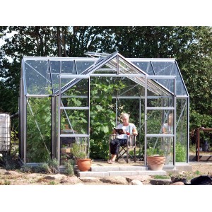 Skleník Vitavia Sirius s hliníkovým rámom, sklom a základom v záhrade.